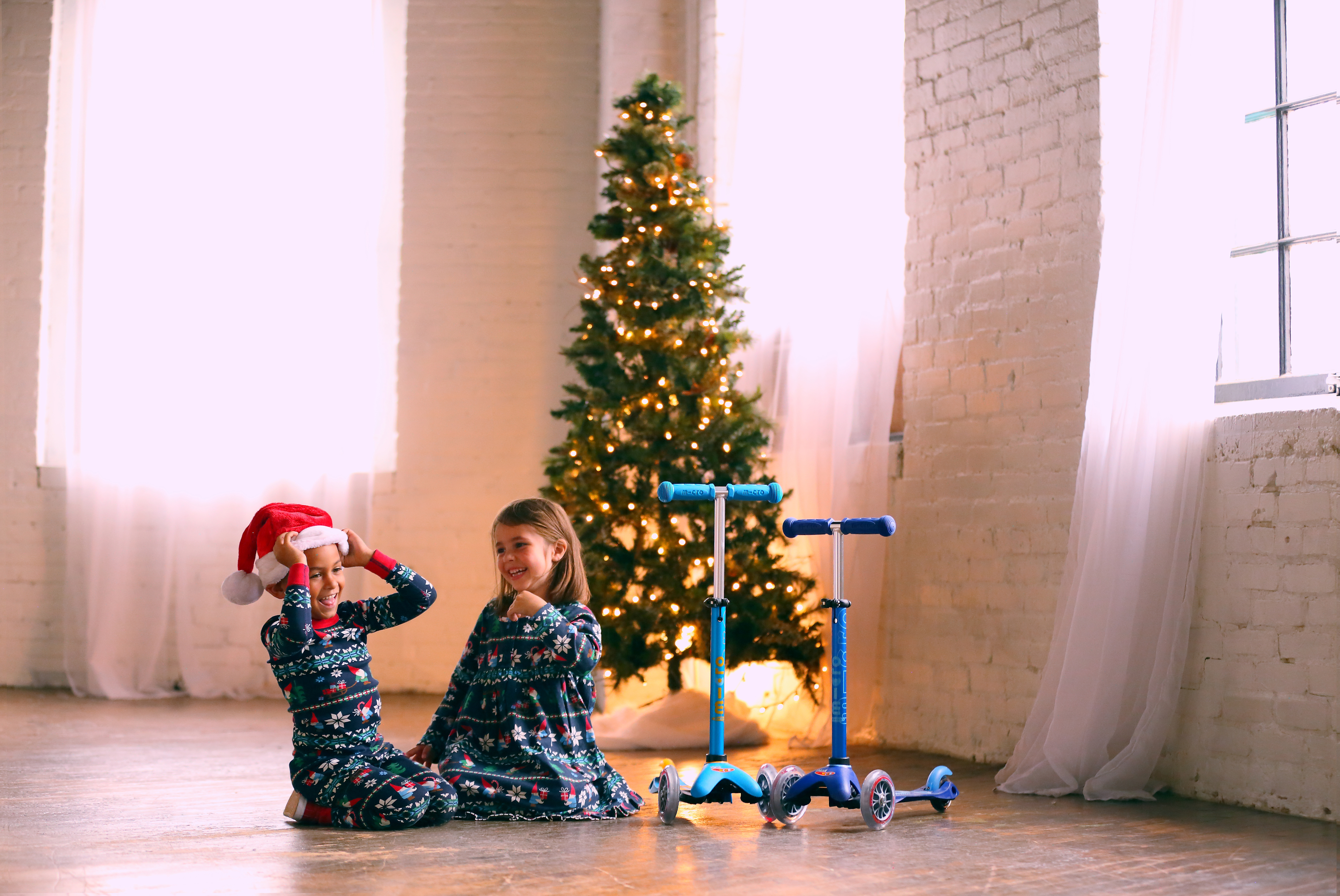 Micro pour Noël Image d'enfants à Noël avec des trottinettes Micro-Mobility