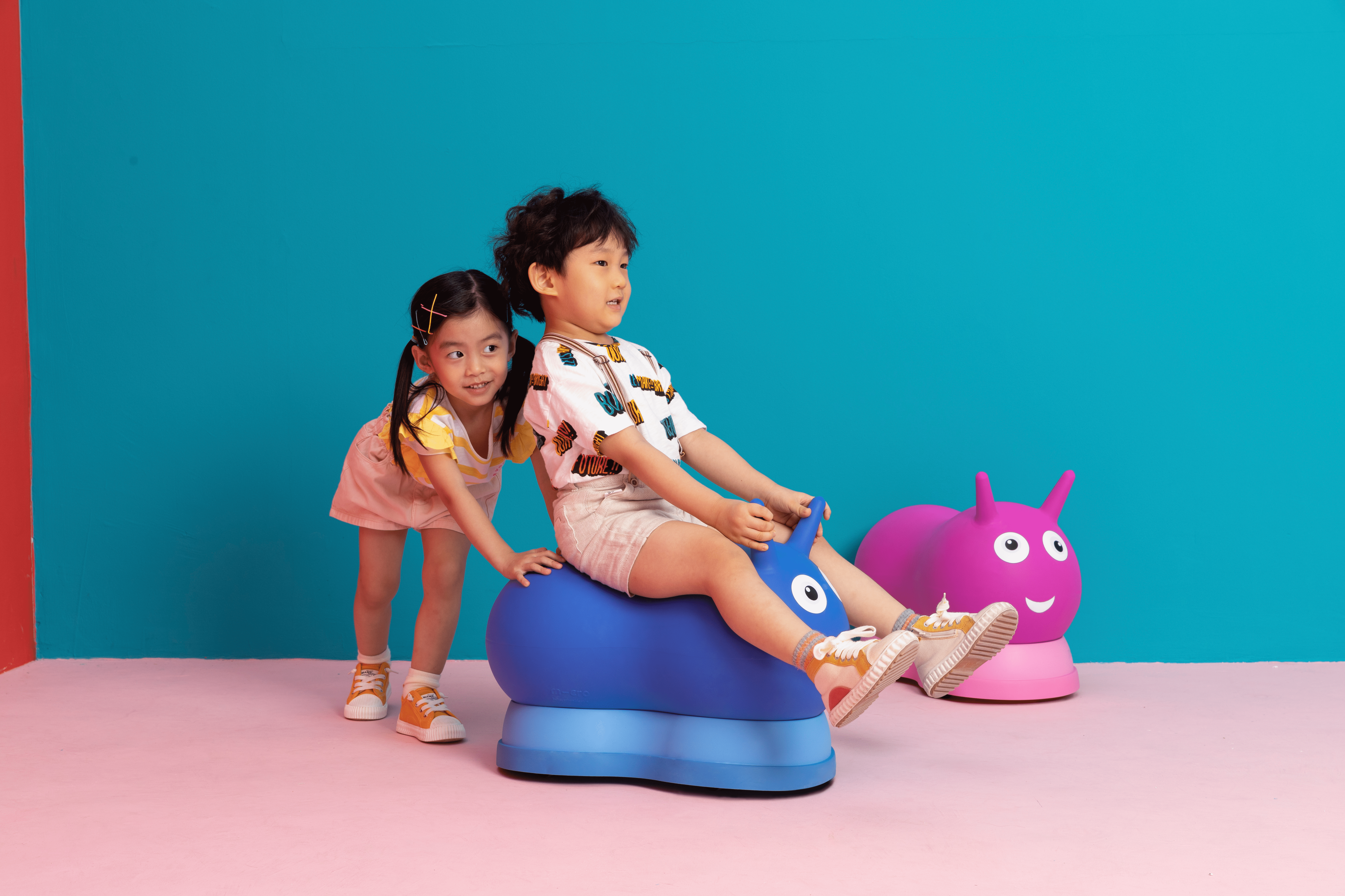 Porteur Micro Air Hopper Bleu et Rose Image petite fille poussant petit garçon sur Porteur Micro Air Hopper Bleu